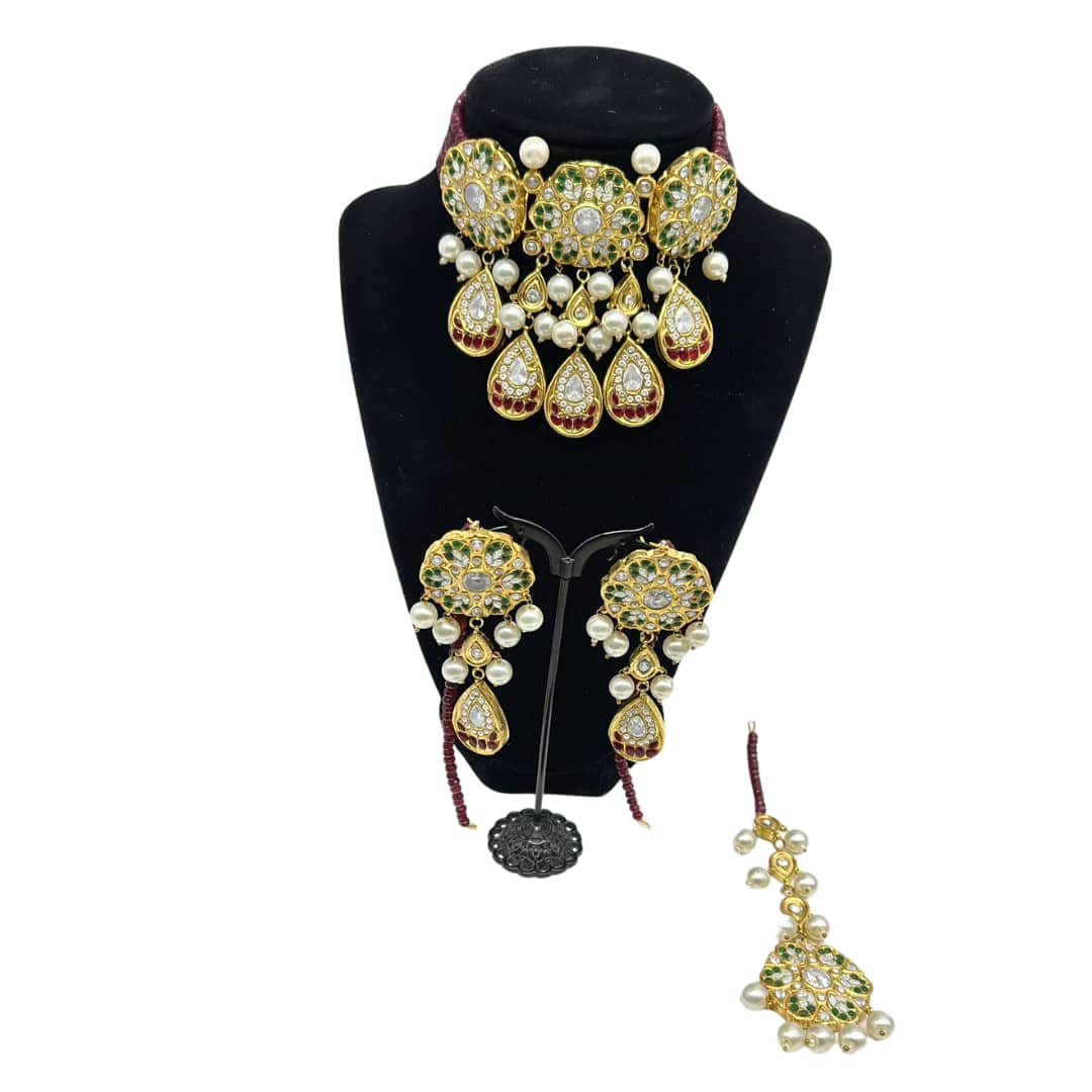 Beautifully crafted kundan set with red crystal strands in ruby, emeralds and pearls